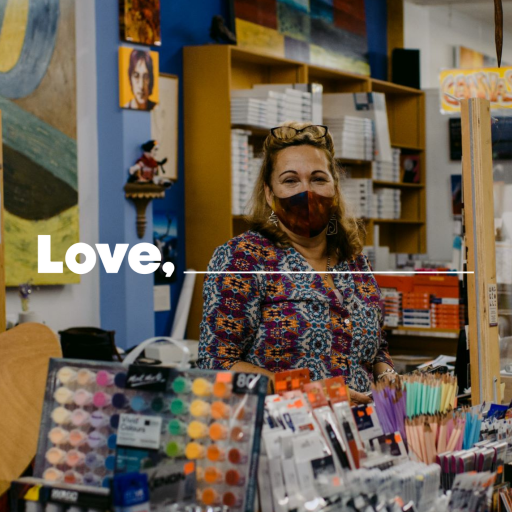 Woman wearing mask standing behind art supplies